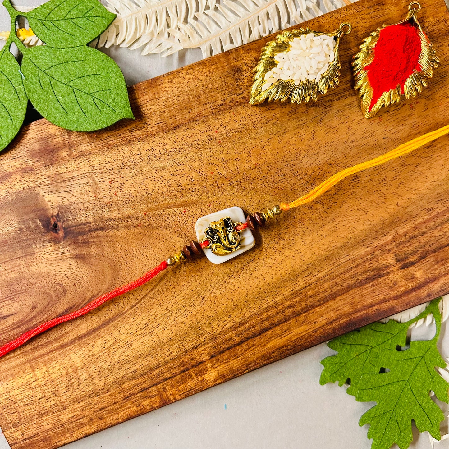 Golden Ganeshji On Off White Bead Rakhi